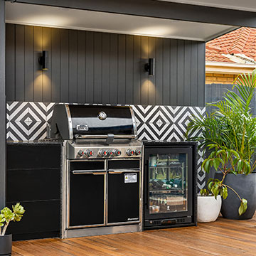 Outdoor kitchen with black and white decorative tiled wall