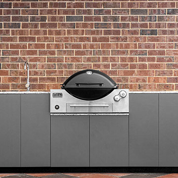 BBQ with sink in front of brick wall